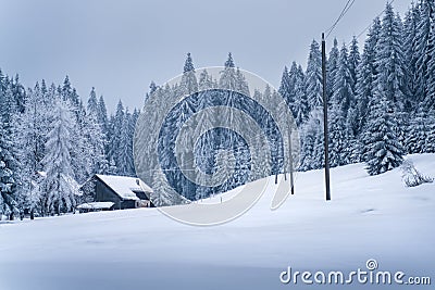 An old house in mountain village buried in snow on a very cold winter day in carpathian mountains, Czech Republic. Power Stock Photo