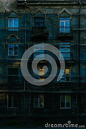 Old house in scaffolding with a beautiful play of light in the windows Stock Photo