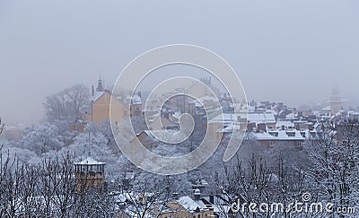 Old houses on a hill in Stockholm on a foggy winter day with snow on, Sweden Stock Photo