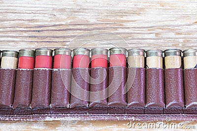 Old hunting cartridges in bandoleer on a wooden table Stock Photo