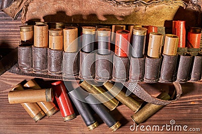 Old hunting cartridges and bandoleer on a wooden table Stock Photo