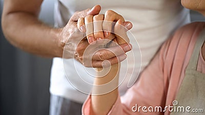 Old husband holding wife hand, spouse care and support, love connection, couple Stock Photo