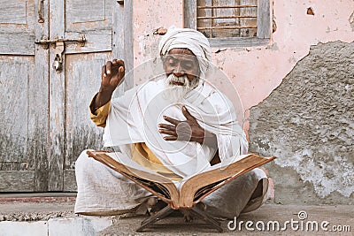 Old indian sadhu reading scriptures. Stock Photo