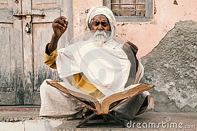 Old indian sadhu reading scriptures. Stock Photo