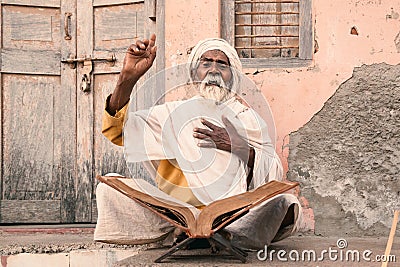 Old indian sadhu speak up sacred scriptures. Stock Photo