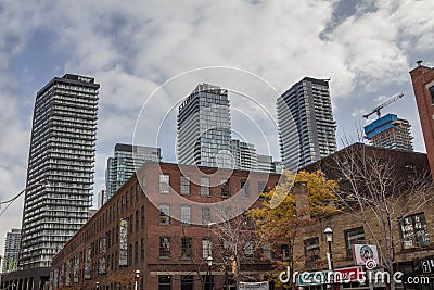 Old individual houses surrounded by high rise condo apartment building towers on Queen Street, in an area of downtown Toronto bei Editorial Stock Photo