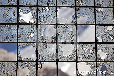 Old Industrial iron window frame rusting with broken glass. Stock Photo