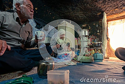 Old Iranian couple in their modest cave home, preparing for dinner. Mahan, Iran Editorial Stock Photo