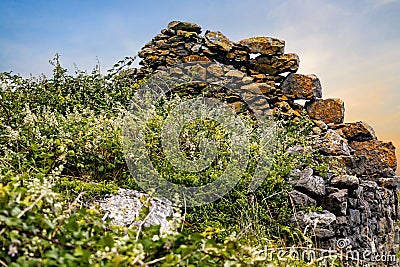 Old Irish celtic buildings stone ruins at coastline Stock Photo