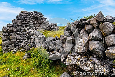 Old Irish celtic buildings stone ruins at coastline Stock Photo