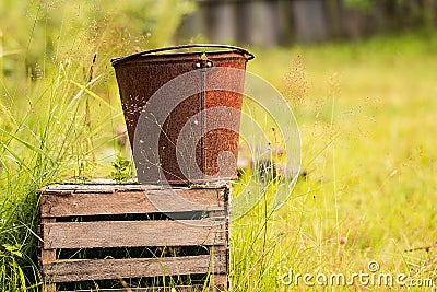 An old iron bucket at wooden pallet Stock Photo