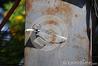 The old iron cabinet is rusty, there is a bolt on the island, the control box is attached to the electrical box outside Stock Photo