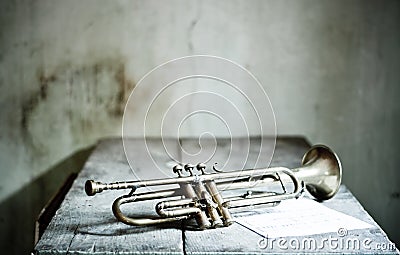 A beautiful jazz trumpet from the 40s with a new musical score over an old wooden table Stock Photo