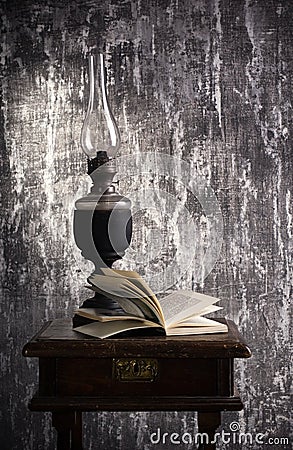 Old kerosene lamp and open book Stock Photo