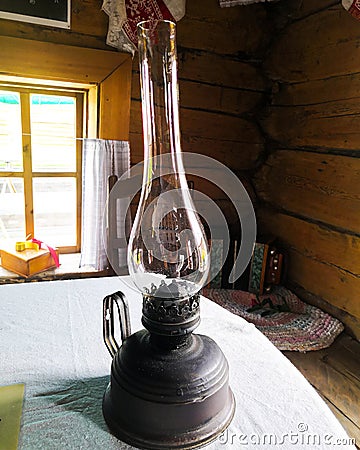 Old kerosene lamp stands on the table. Still life with dusty antique kerosene lamp Stock Photo