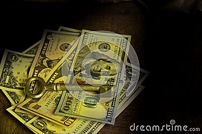 Old key laying on top of stack of cash money. Happiness concept. Stock Photo