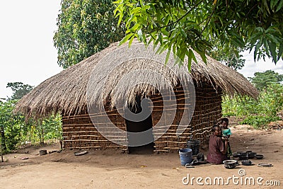 Old lady from Makonde tribe sitting in primitive kitchen and preparing local traditional meal Editorial Stock Photo