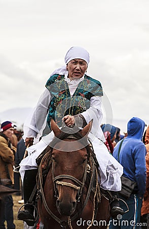 A Old Lady rides horse at Song Kul Lake in Kyrgyzstan Editorial Stock Photo