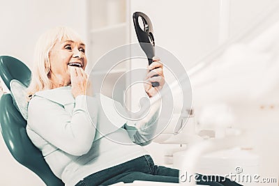 Old lady viewing her new teeth Stock Photo