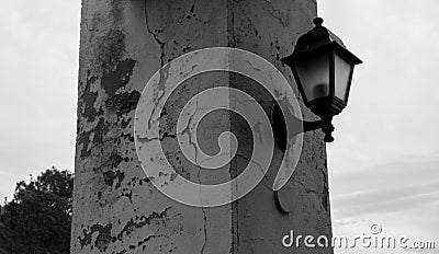 Old lantern on the cracked column with background on the sky Stock Photo