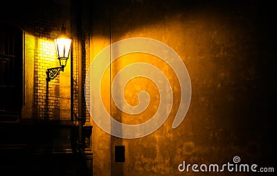 Old lantern illuminating a dark alleyway corner wall at night in Prague, Czech Republic Stock Photo