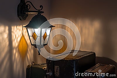 Old latern on a wall and suitcases Stock Photo