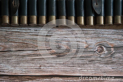 Old leather bandolier with cartridges close-up on a wooden background Stock Photo