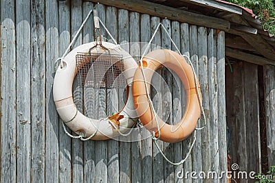 Old lifebuoys on a log wall Stock Photo