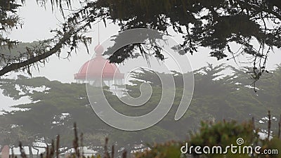 Old lighthouse fresnel lens glowing, foggy rainy weather. Illuminated beacon USA Stock Photo