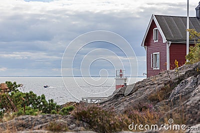 Old lighthouse, house and boat entering the sea gate in the Baltic Sea, selective focus Stock Photo