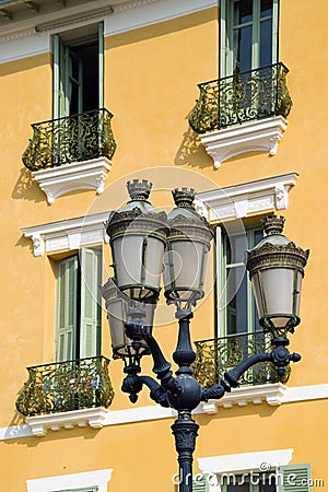 Old lights contrasted against old yellow French apartments Stock Photo