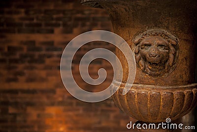 Old lion flower vase in front of a brick wall Stock Photo