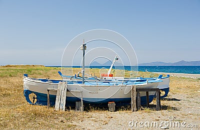 Old, little fishing ships are standing at the ground next to the sea in Sicily, Italy Stock Photo