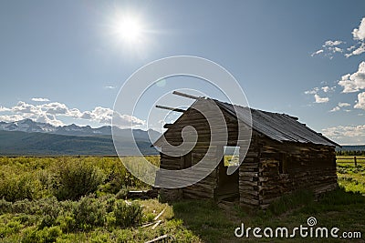 Old log cabin on a meadow near Stanley Idaho with Sawtooth mountains Stock Photo