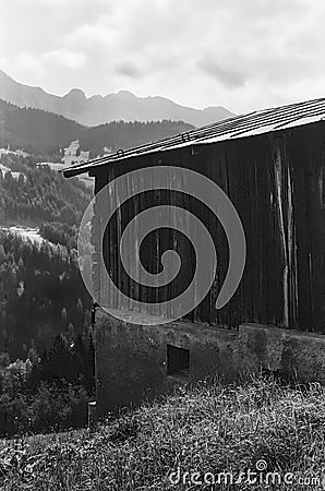 Old log huts for animal shelters with the Swiss Alps in the background, shot with with analogue photography technique Stock Photo