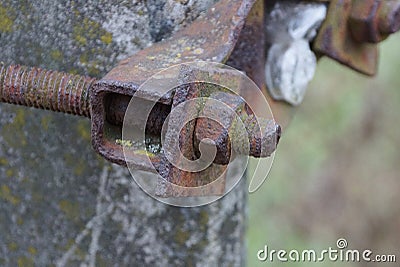 Old long rusty brown metal construction from a nut and a bolt on plates Stock Photo