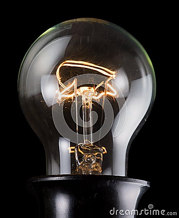 Old luminescent electric lamp on black Stock Photo