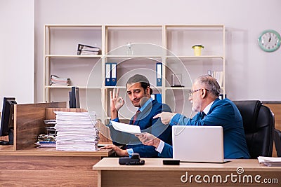 Old male boss and his young male assistant in bullying concept Stock Photo