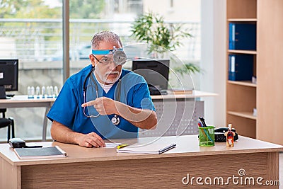Old male doctor laryngologist working in the clinic Stock Photo