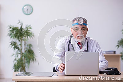 Old male doctor otologist working in the clinic Stock Photo