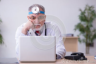 Old male doctor otologist working in the clinic Stock Photo