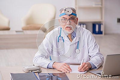 Old male doctor otologist working in the clinic Stock Photo
