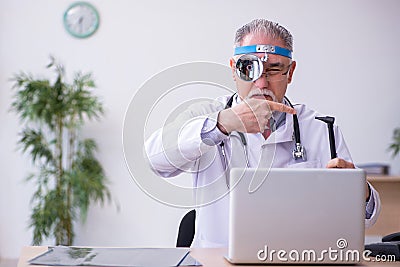 Old male doctor otologist working in the clinic Stock Photo