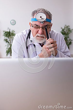 Old male doctor otologist working in the clinic Stock Photo