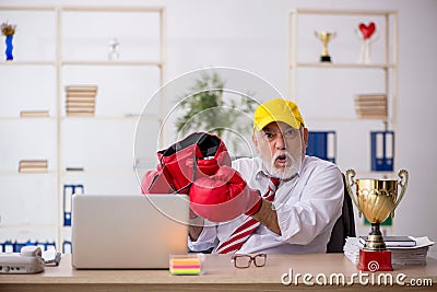 Old male employee boxer being awarded with golden cup Stock Photo