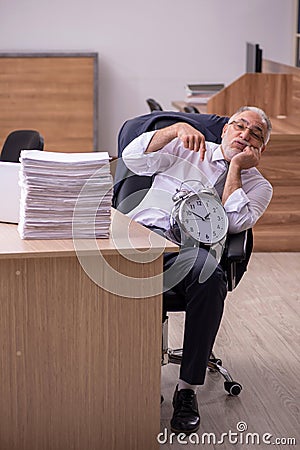 Old male employee in time manegement concept Stock Photo