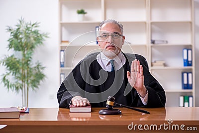 Old male judge working in courthouse Stock Photo