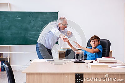 Old male teacher and schoolboy in the classroom Stock Photo