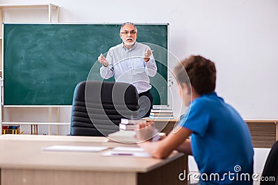 Old male teacher and schoolboy in the classroom Stock Photo