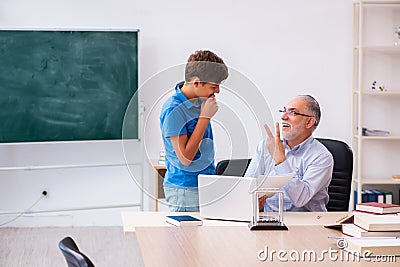 Old male teacher and schoolboy in the classroom Stock Photo